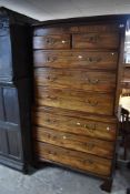 A George III mahogany chest on chest, having a dentil moulded cornice and inlaid frieze over two