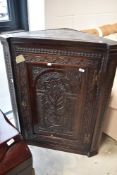 A period oak carved corner cupboard, height approx. 108cm