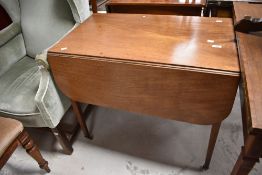 A Victorian mahogany pembroke table having square tapered legs and brass castors