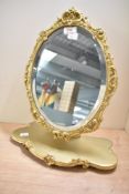 A mid to late 20th-century Peerart Rococo-style gilded resin oval mirror, fitted to a stand,