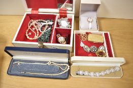 A cream faux leather jewellery box, containing an assortment of costume jewellery including