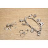 A silver charm bracelet having a padlock clasp and seven charms including football boots and