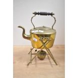 A late 19th to early 20th century brass spirit kettle on a stand with a burner, featuring a turned