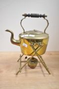 A late 19th to early 20th century brass spirit kettle on a stand with a burner, featuring a turned