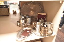 A selection of pewter and silver-plated ware comprising hip flask, serving platters and tankards
