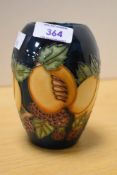 A 20th-century Moorcroft Pottery vase, featuring soft tube-lined grape and peach decoration,