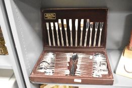 A 20th-century Japanese Stainless steel cutlery canteen, in a chocolate brown display case, to