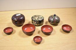 A nested set of mid 20th-century Japanese wooden lacquerware bowls/saki cups with colourful red