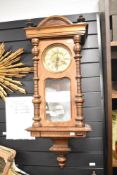 A 19th-century Vienna-style wall clock, featuring a carved wooden case, ornately turned columns