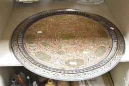A large Middle Eastern circular copper tray featuring intricate geometric and calligraphic