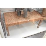 A large 20th-century Indian hand-carved wooden table, featuring intricate open fret work of
