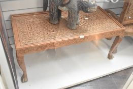 A large 20th-century Indian hand-carved wooden table, featuring intricate open fret work of