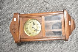 An early 20th-century oak mechanical wall clock, featuring Arabic numerals, a classic rectangular