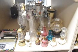 A selection of 20th century oil lamps and oil lamp parts, including five loose flutes.