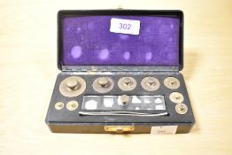 A complete set of 20th-century apothecary balance weights in a case with smaller fractional