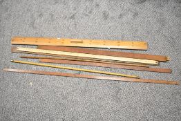A group of eight wooden measures and rulers including a Marksman mathematics blackboard ruler, a '