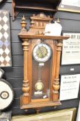 A large 19th-century Vienna mahogany wall clock, with ornate carved decoration and turned finials,