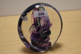 A contemporary Jane Charles studio art glass paperweight, of elongated orb-form featuring a