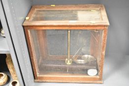 A large 20th-century chemistry analytical balance scale housed in a wooden and glass case, having