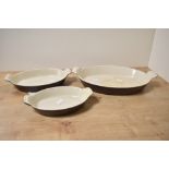 A set of three chocolate brown enamelled Le Creuset dishes, marked to base, (3), used condition.
