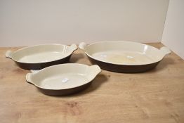 A set of three chocolate brown enamelled Le Creuset dishes, marked to base, (3), used condition.