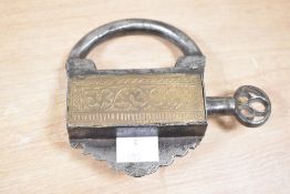 A late 19th to early 20th century Mughal iron and brass padlock, with a screw type key, of ornate
