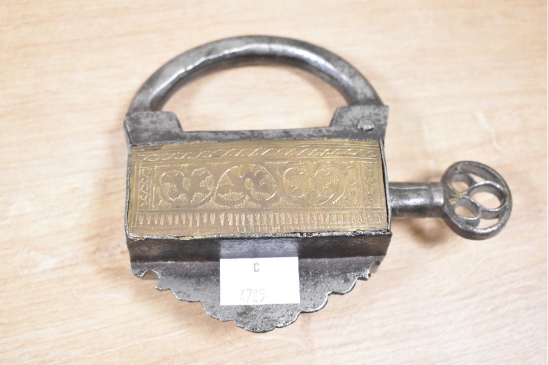 A late 19th to early 20th century Mughal iron and brass padlock, with a screw type key, of ornate - Image 1 of 2