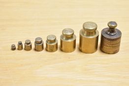 A set of eight 20th-century brass apothecary weights, with plastic storage box, (8), condition is