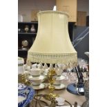 A 20th-century classic-style table lamp, having a brass-toned base and cream-coloured fabric shade