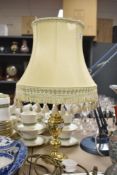 A 20th-century classic-style table lamp, having a brass-toned base and cream-coloured fabric shade