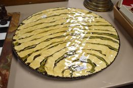 A large 20th century studio pottery slipware ceramic serving platter having yellow and green