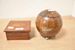 An early 20th-century Art Deco circular oak tobacco caddy, featuring a hinged lid, scrolled metal
