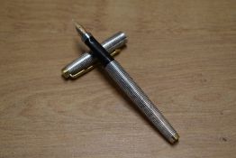 A Parker 75 converter fill fountain pen in Sterling Silver Cisele with gold trim having Parker 14K