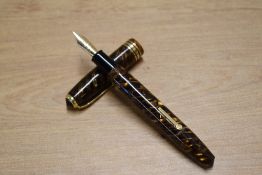 A boxed Conway Stewart 58 lever fill fountain pen in Tiger's Eye with one broad and two narrow cap