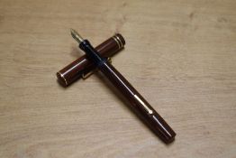 A Wahl lever fill fountain pen in Red and Black woodgrain with two narrow cap bands having a Wahl