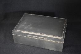 A late Edwardian silver table top cigar box, of hinged rectangular form having a decorative embossed