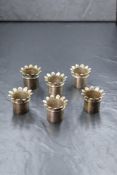 A set of six George IV silver serviette holders, of circular form having flared floral decoration to