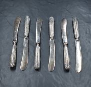 A cased set of George V silver handled butter knives, having bead thread decoration and silver