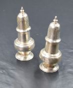 A matched pair of George V silver pepperettes, of bulbous form having moulded decoration, raised
