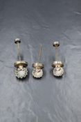 Three white metal shell motif bottle cork stoppers, having shell motif top handles with moulded