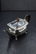 A Victorian silver teapot, of rectangular form having a shell and gadrooned rim, raised on four