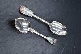 A matched pair of Victorian silver fiddle and shell pattern serving spoons, having dog heraldic