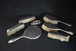 A George V silver mounted vanity set, comprising a hand mirror, two hair brushes, with two matched