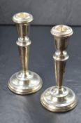 A pair of Elizabeth II silver candlesticks, of traditional form having circular sconces with bead