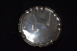 An Elizabeth II silver salver, of circular form having a Chippendale style rim, raised on four
