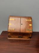 A Victorian walnut stationery cabinet with a sloping fall enclosing a fitted interior and calendar