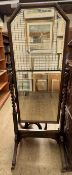 An oak framed cheval mirror with a bevelled plate splayed legs and casters