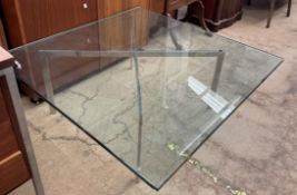 A glass and chrome coffee table of square form