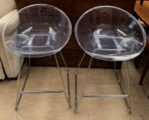 A pair of mid 20th century polycarbonate and chrome bar stools with circular seats on chrome bases
