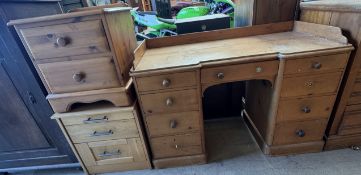 A pine pedestal desk with an inverted front and two banks of four drawers on a plinth base together